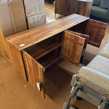 Wooden sideboard with open doors in a room with boxes and furniture.