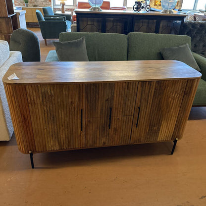 Wooden sideboard in a room with green sofa and other furniture.