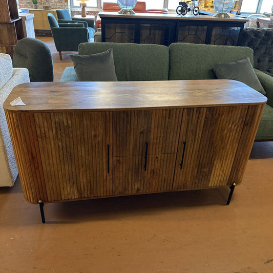 Wooden sideboard in a room with green sofa and other furniture.