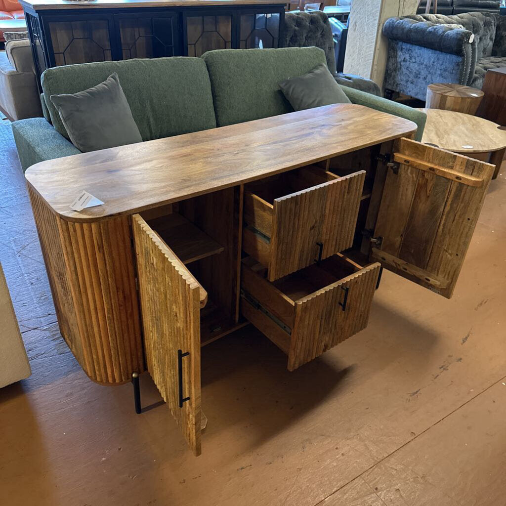 Wooden sideboard with open doors and drawers in a room with furniture.