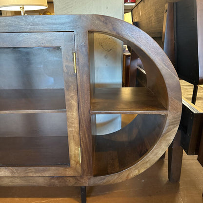 Wooden circular shelf with glass panels in a room setting
