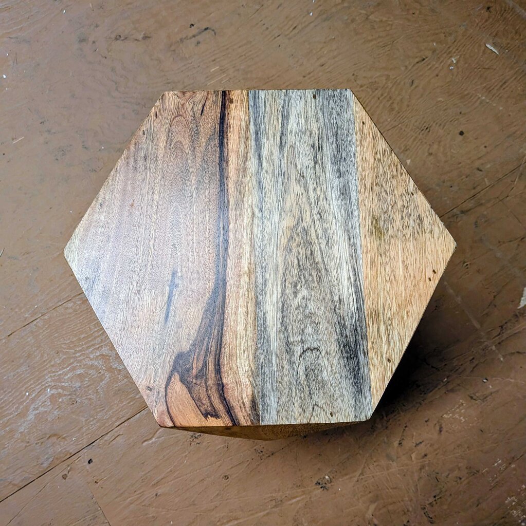 Hexagonal wooden coaster on a wooden surface