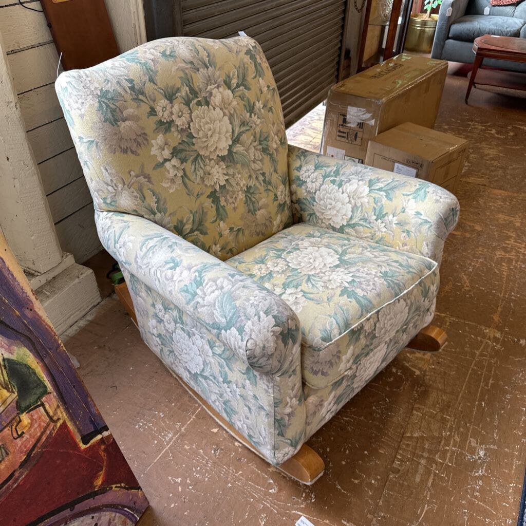 Floral-patterned armchair in a room with boxes and furniture.