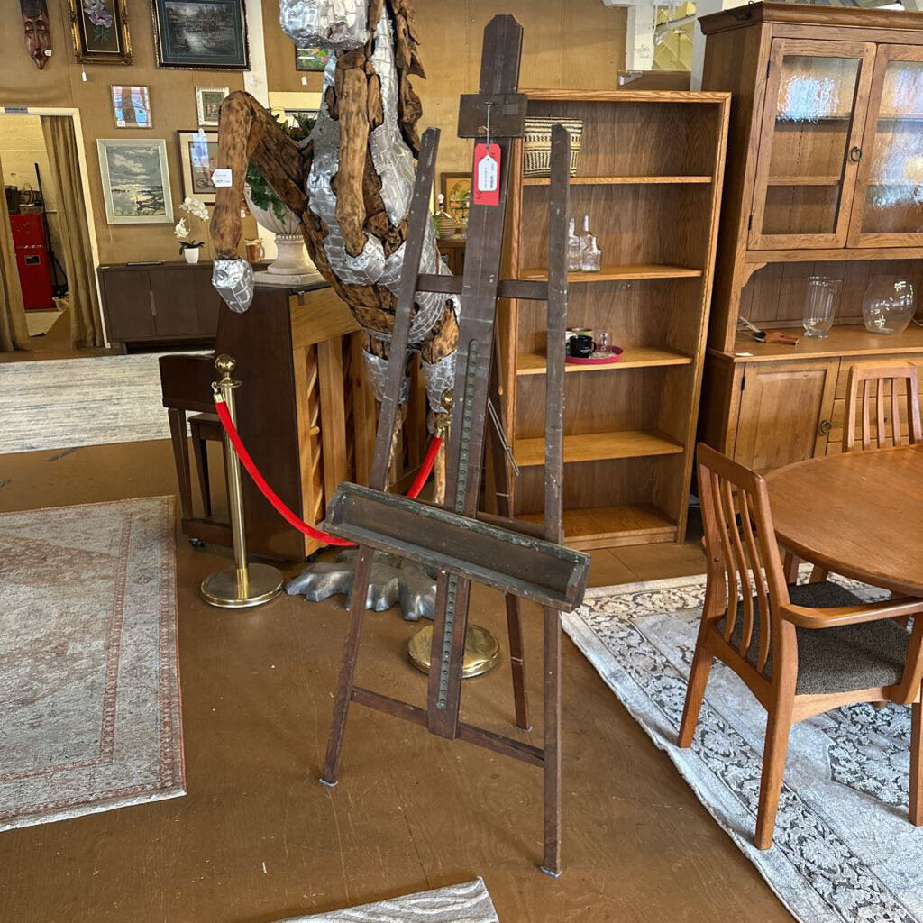 Wooden furniture including a table, chairs, and bookshelves in an indoor setting.