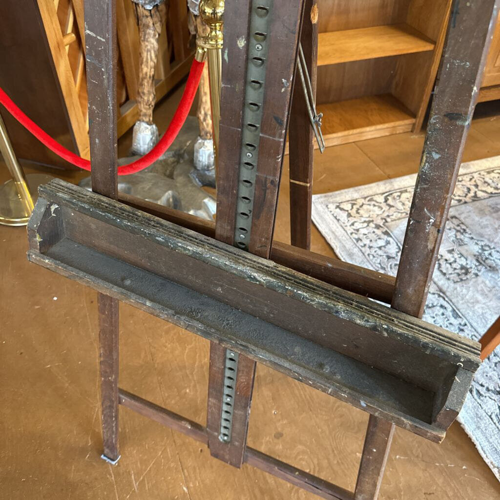 Metal frame structure on a wooden floor with a red rope barrier in the background