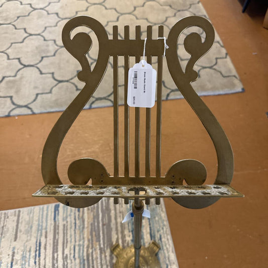 Decorative metal lyre on a surface with a tag attached