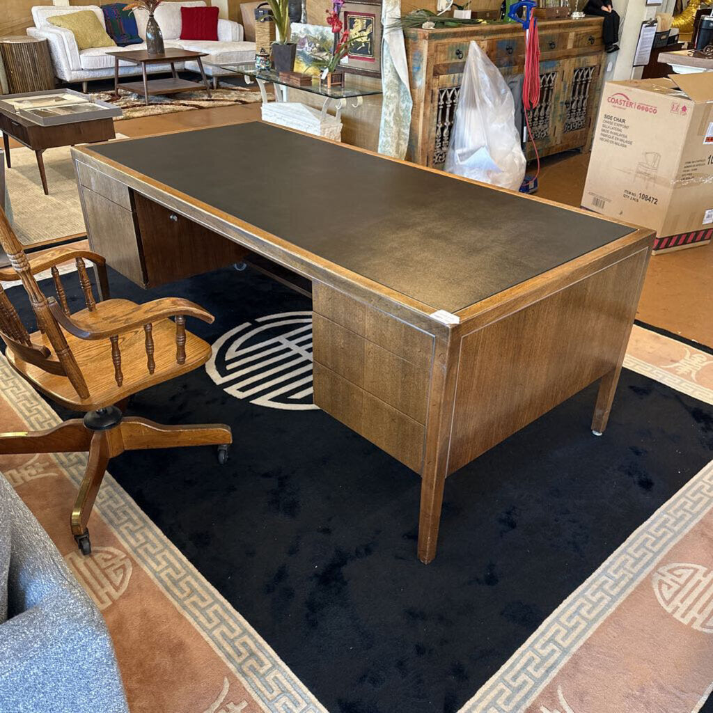 Wooden desk with a chair in a room with furniture and boxes