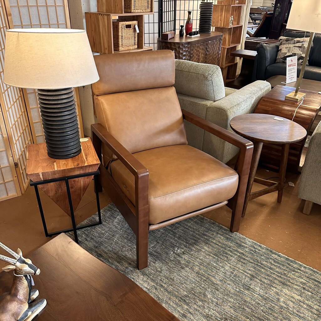Brown leather armchair in a room with wooden furniture and decor