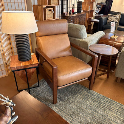 Brown leather armchair in a room with wooden furniture and decor