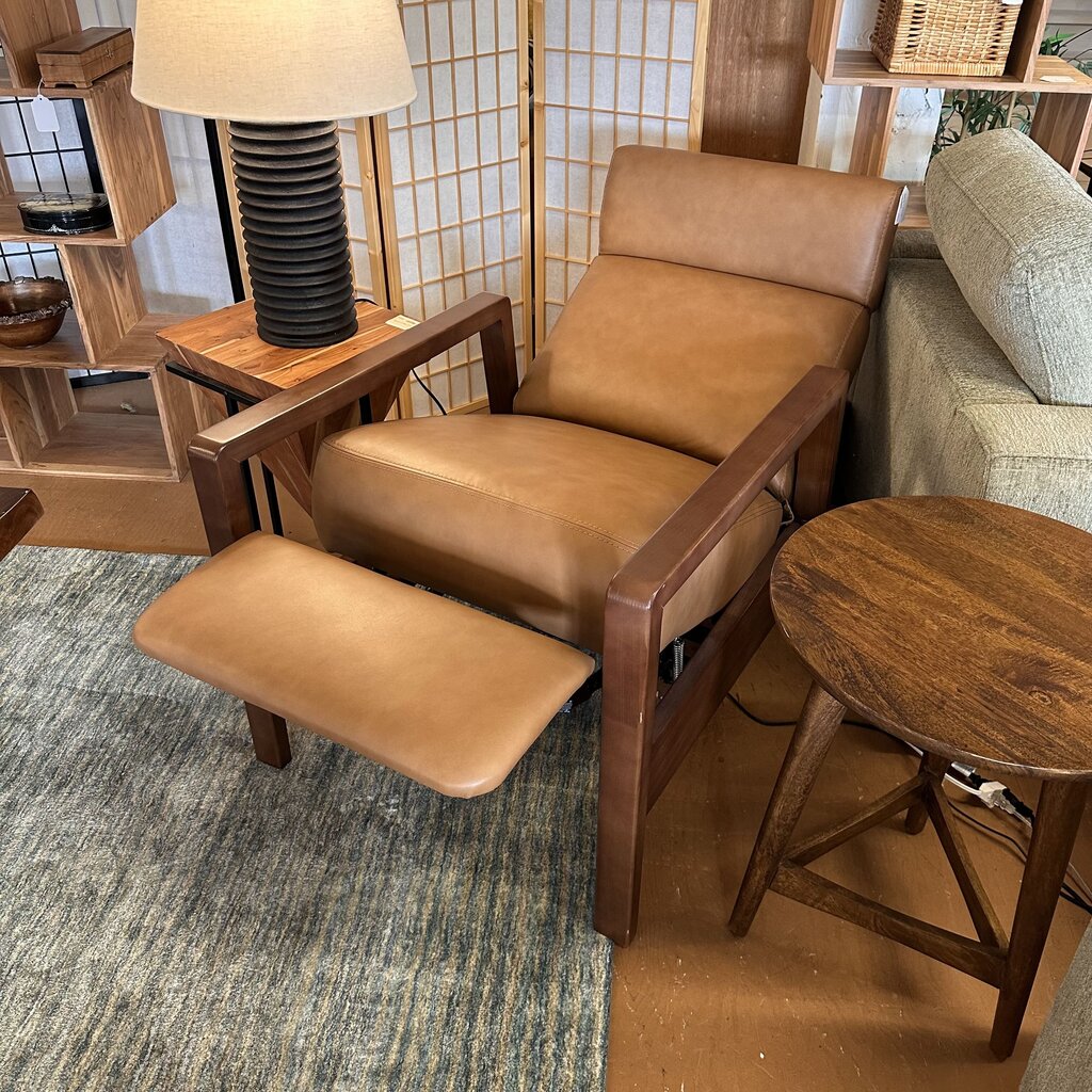 Brown leather recliner chair in a room with wooden furniture and a rug.
