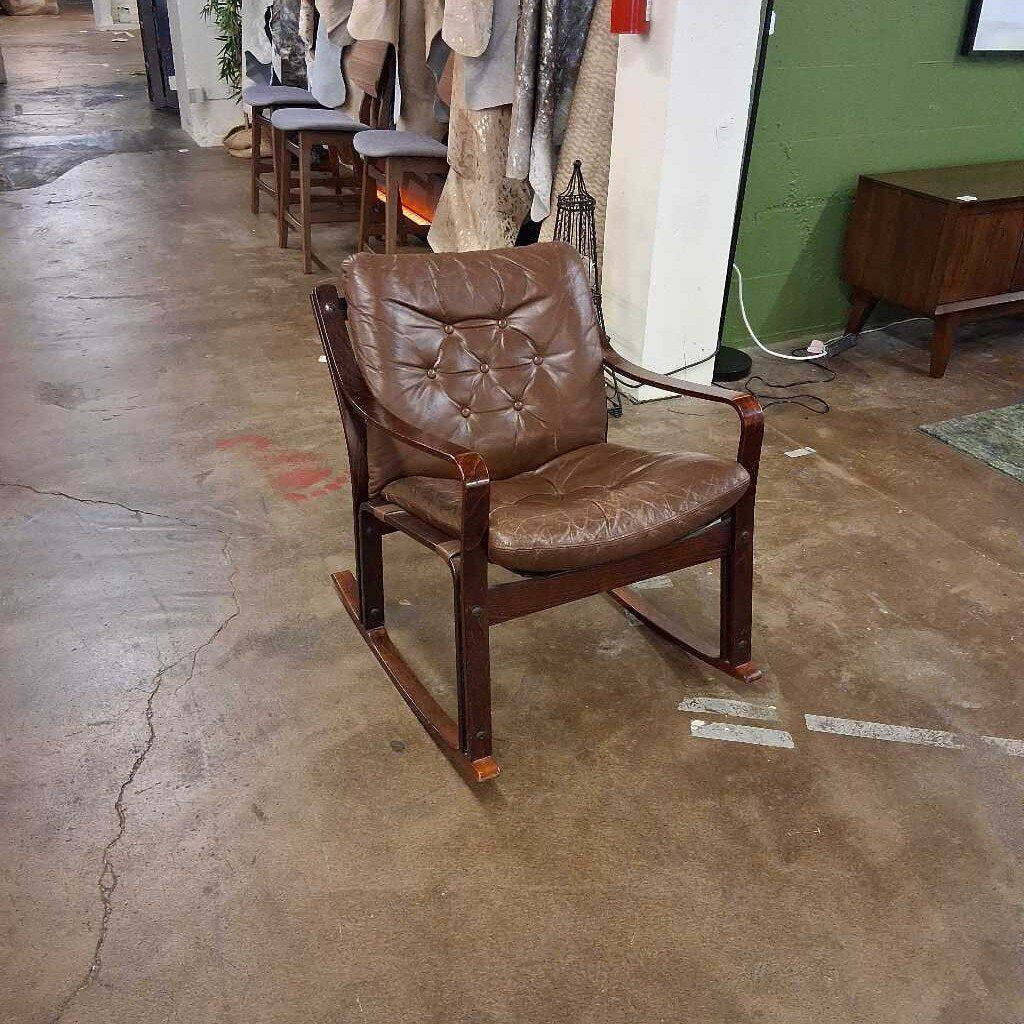Brown leather rocking chair on a concrete floor