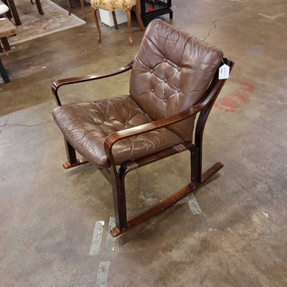 Brown leather rocking chair on a concrete floor