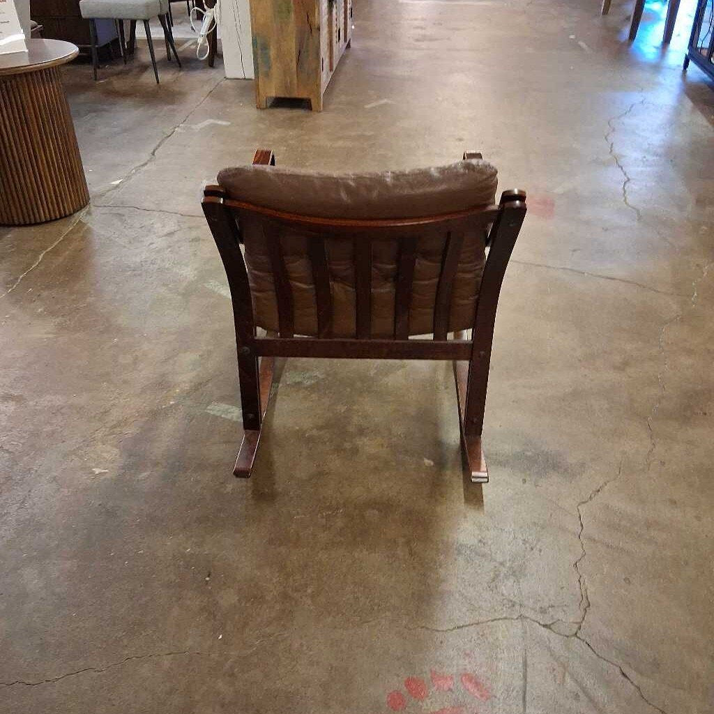 Brown leather rocking chair on a concrete floor