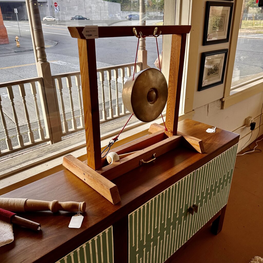 Gong on a stand in front of a window with a view of a street.