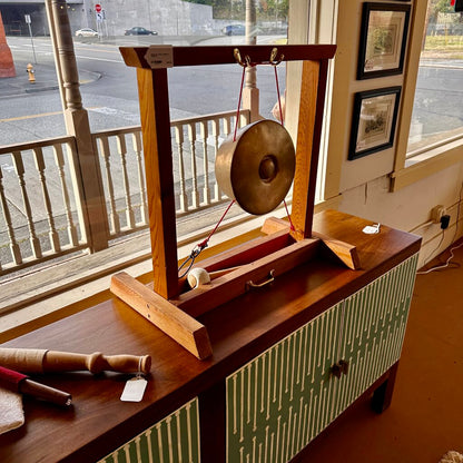 Gong on a stand in front of a window with a view of a street.