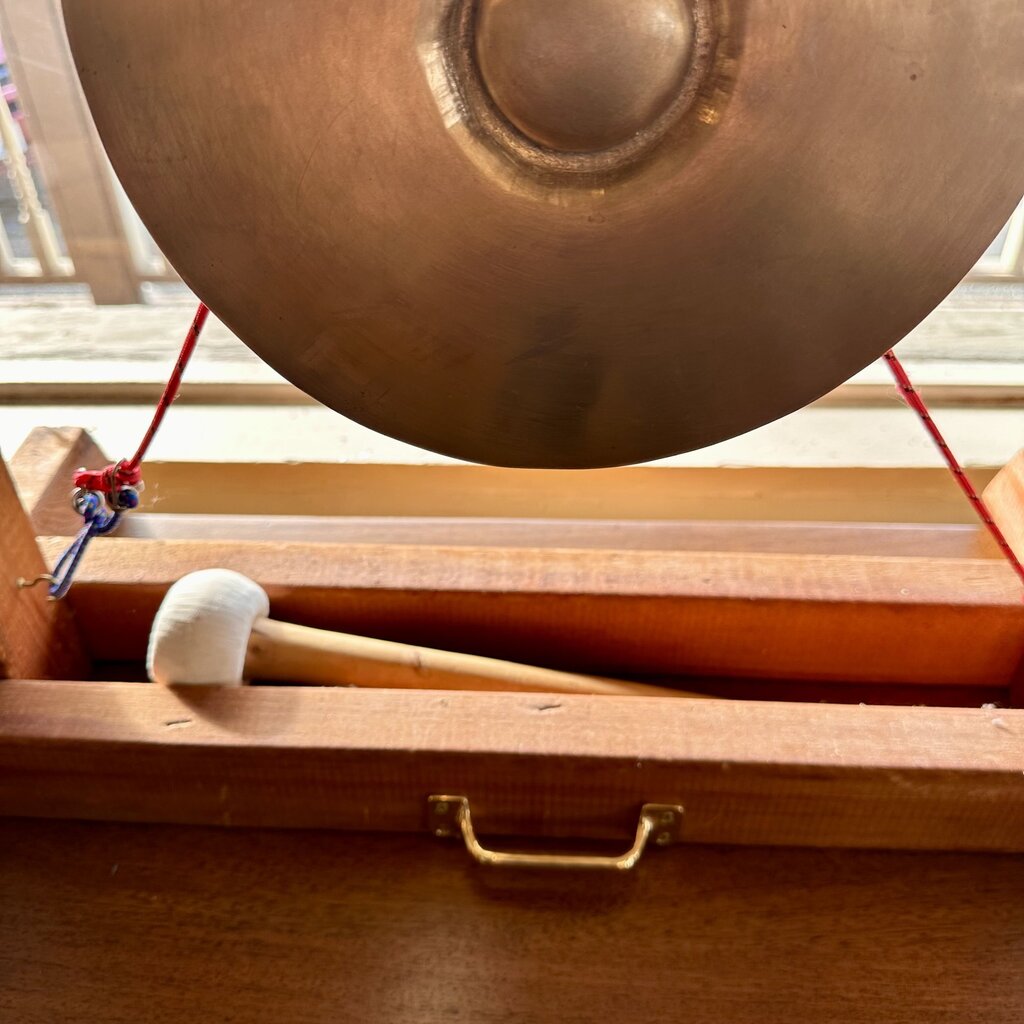 Copper gong with wooden mallet on a wooden stand