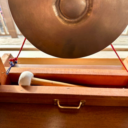 Copper gong with wooden mallet on a wooden stand