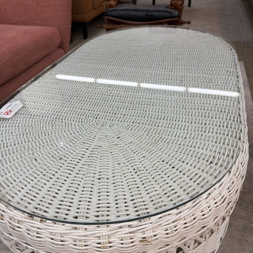Round wicker table with a glass top in a room setting