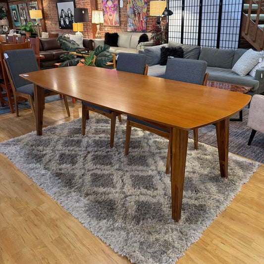 Wooden dining table with chairs in a living room setting