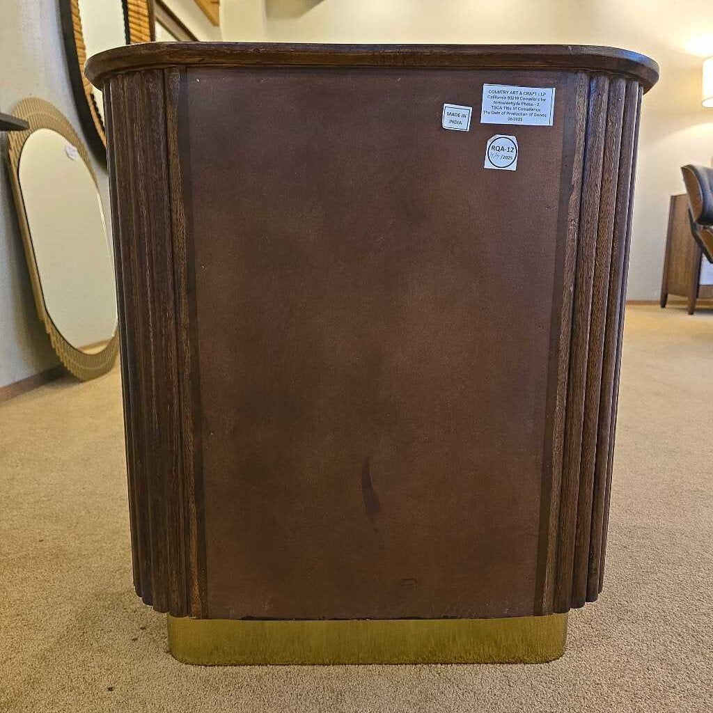 Brown wooden side table with visible wear and two labels on a carpeted floor.