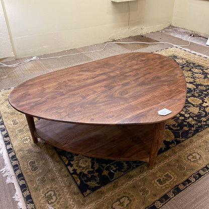 Wooden coffee table on a patterned rug with a plain wall background