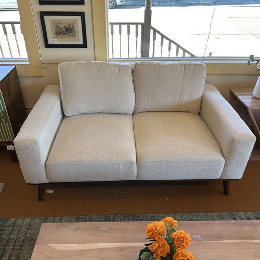 Beige sofa in a room with a coffee table and flowers