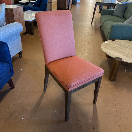 Chair with pink backrest and seat in a furniture store setting