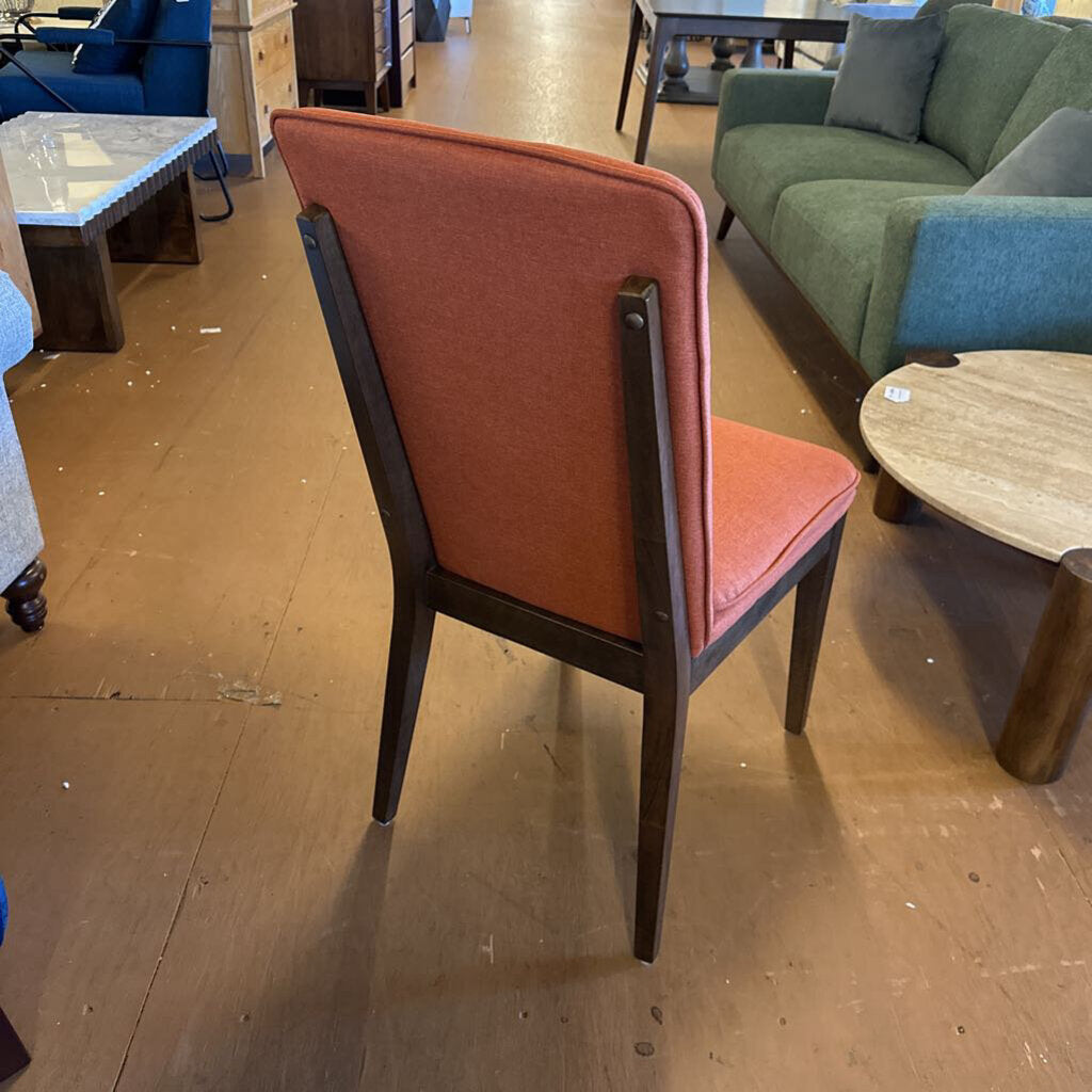 Chair with red cushioned backrest and seat in a furniture store setting