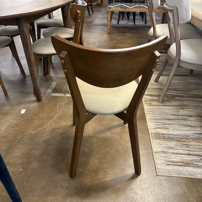 Wooden chair with a white cushion on a showroom floor