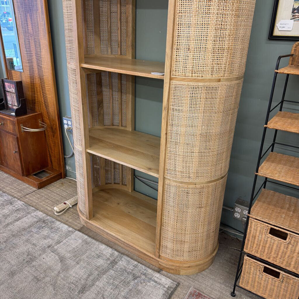 Wooden bookshelf with wicker accents in a room setting