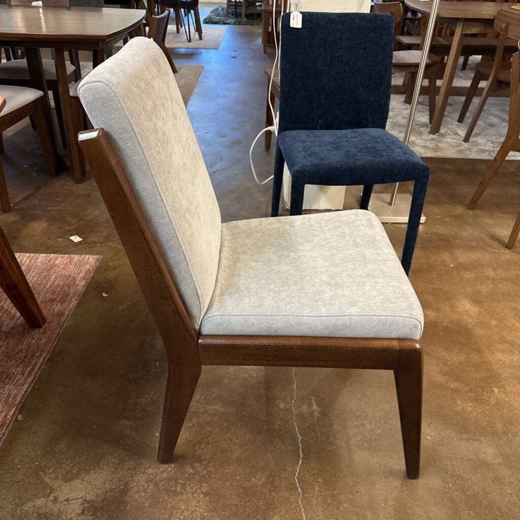 Chair with wooden frame and gray cushioned seat in a store setting