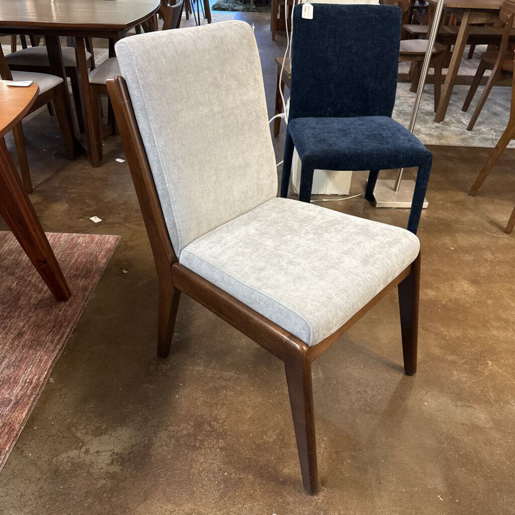 Chair with wooden frame and upholstered seat and backrest in a store setting