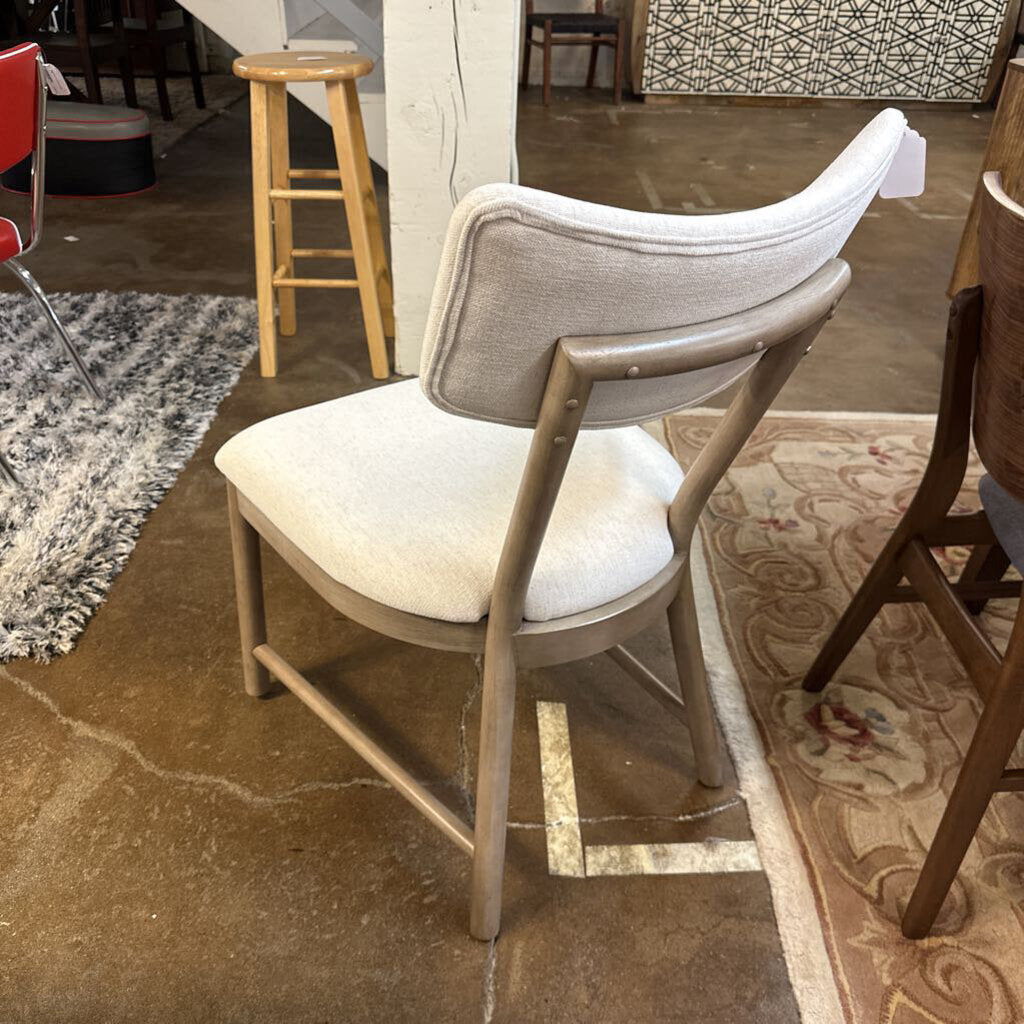 Chair with a white cushion on a tiled floor in a casual setting