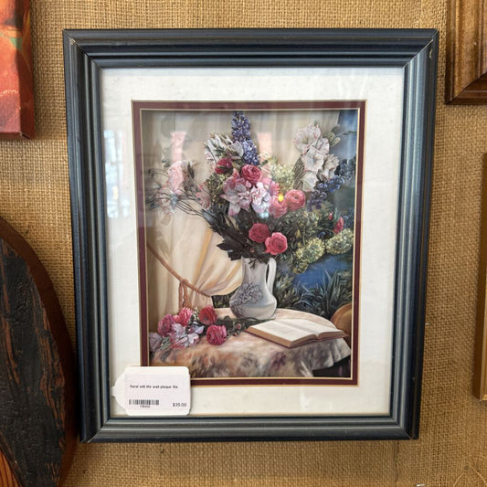 Framed still life painting with flowers and an open book on a table.