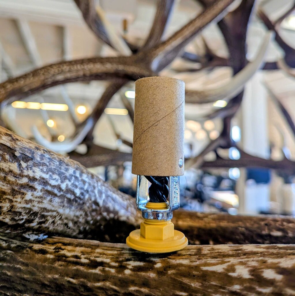 Cork stopper with yellow base on a wooden surface with antlers in the background