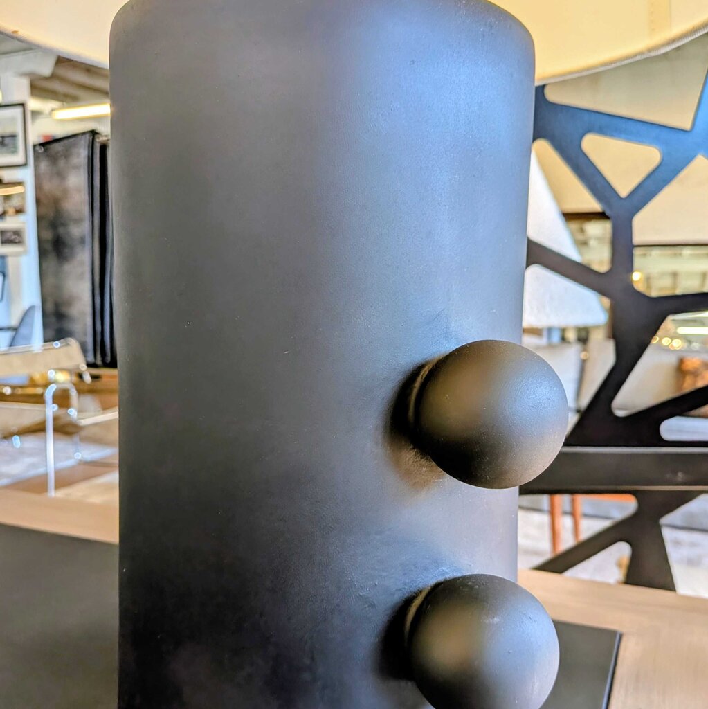 Close-up of a textured cylindrical object with spherical knobs in an indoor setting