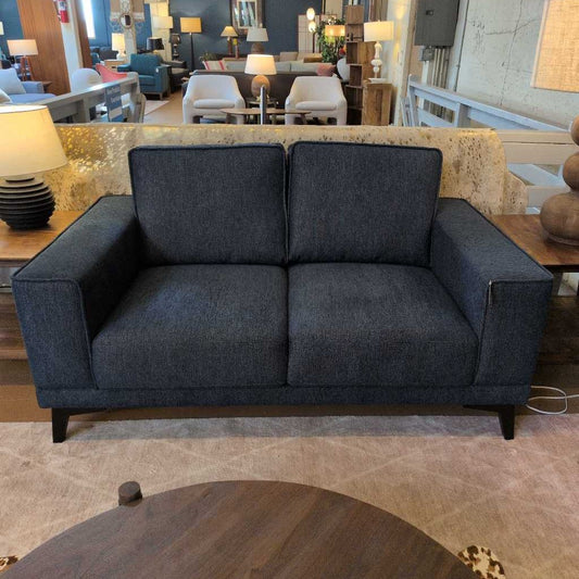 Blue sofa in a room with chairs and tables