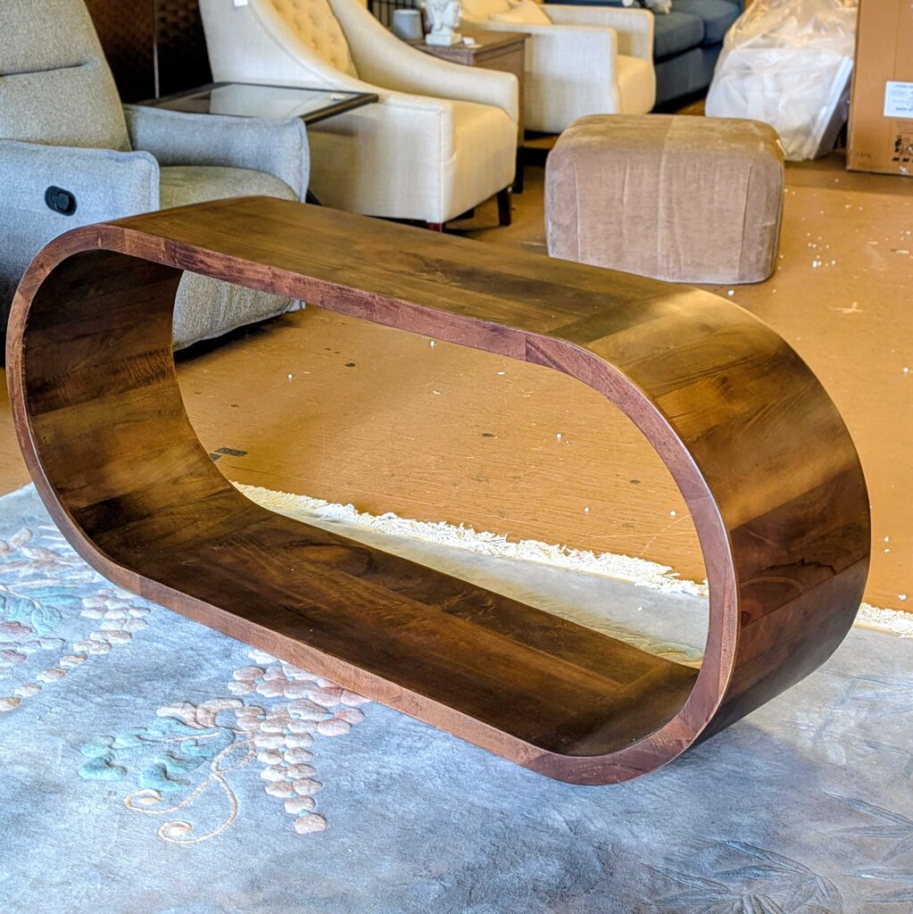 Wooden coffee table with a wavy design in a room with furniture