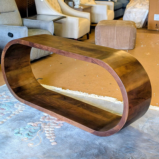Wooden coffee table with a wavy design in a room with furniture
