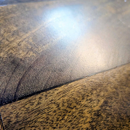 Close-up of a wooden surface with a reflective spot
