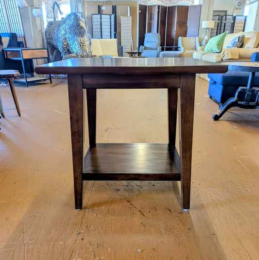 Wooden side table in a showroom with furniture in the background