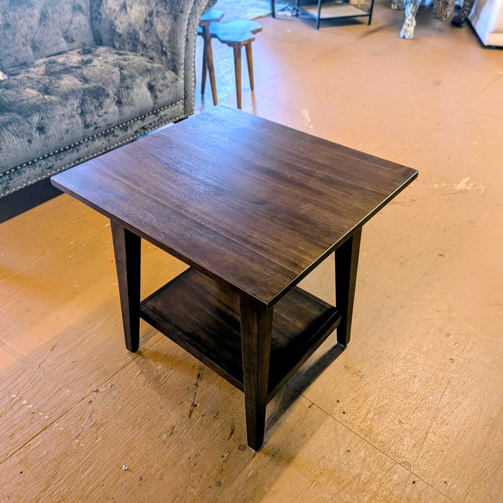 Wooden side table in a showroom with furniture in the background