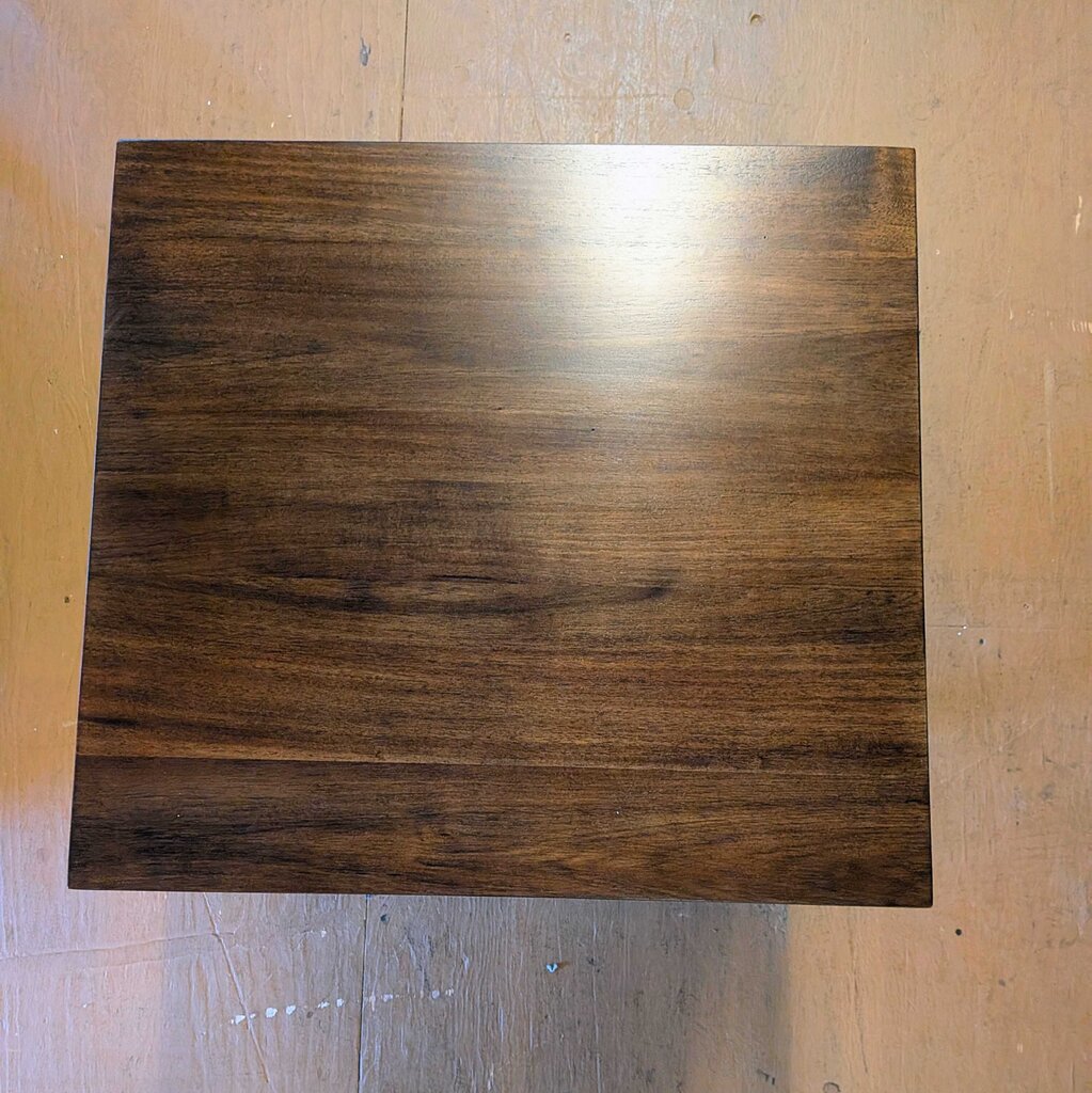 Wooden side table in a showroom with furniture in the background