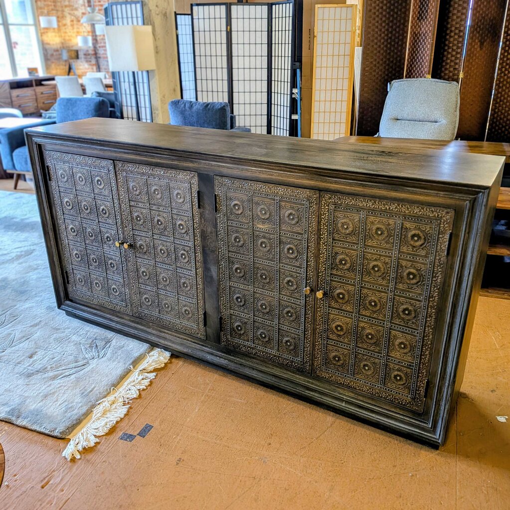 Decorative wooden cabinet with intricate patterns in a showroom setting