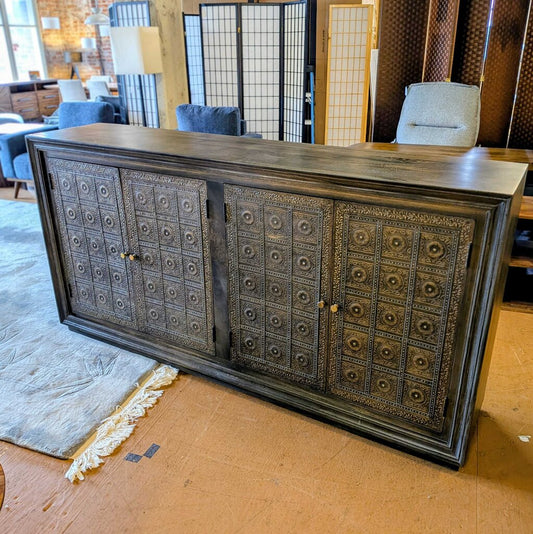 Decorative wooden cabinet with intricate patterns in a showroom setting