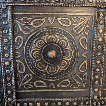 Decorative metal panel with intricate patterns and embossed designs.