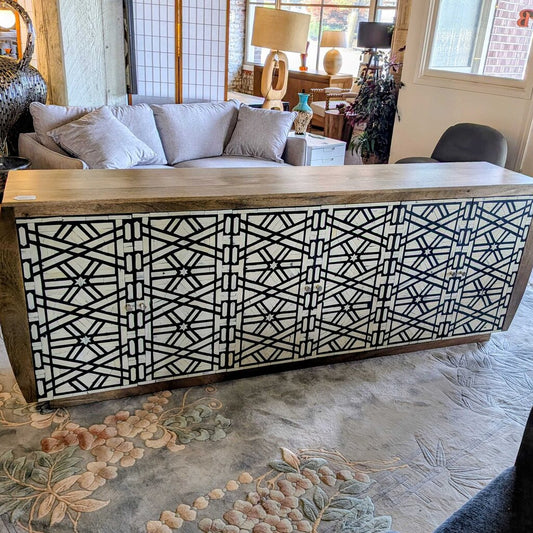 Wooden console table with geometric pattern in a living room setting
