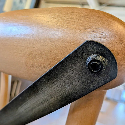 Close-up of a wooden chair arm with a metal bracket.
