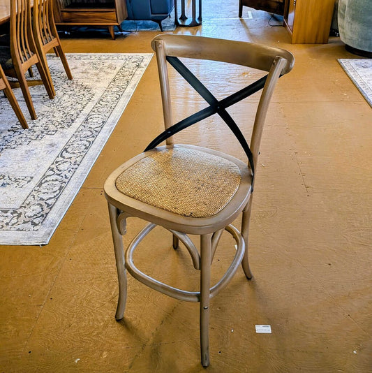 Wooden bar stool with wicker seat on a wooden floor
