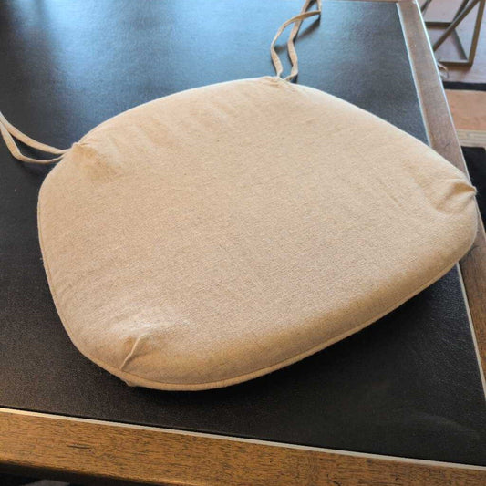 Beige seat cushion on a dark surface